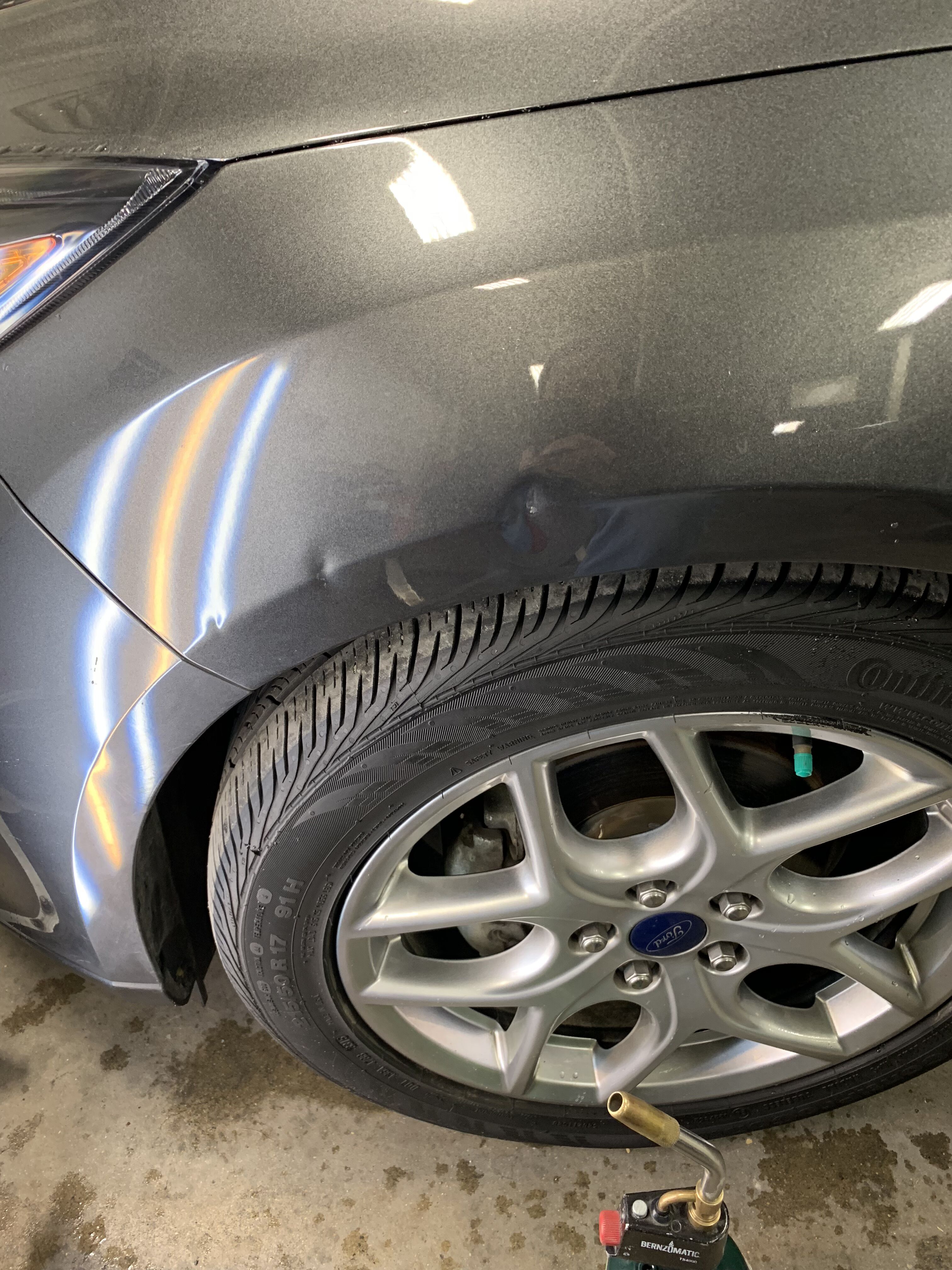 a ford with a couple small dents on the fender