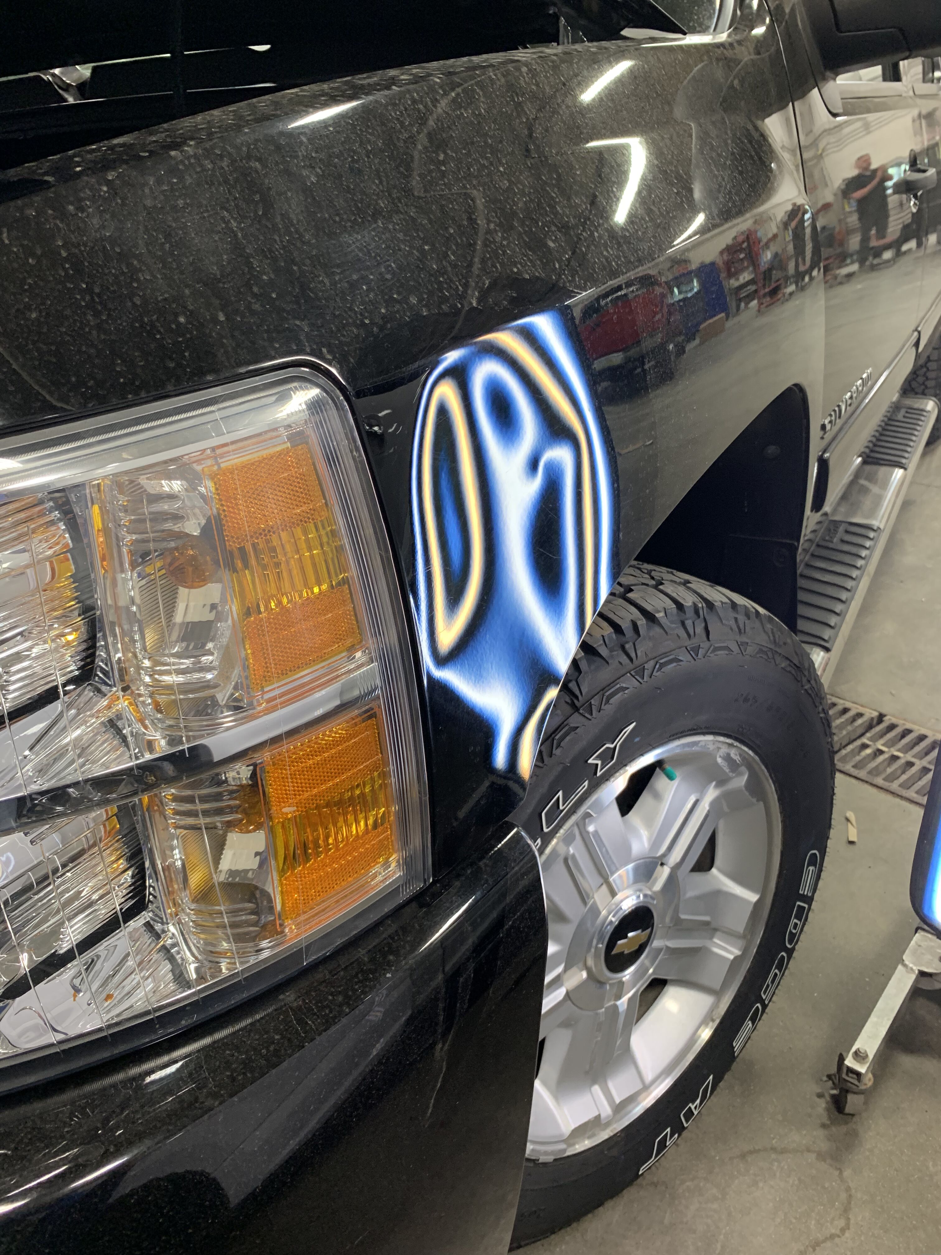 a silverado with a dent on the front fender