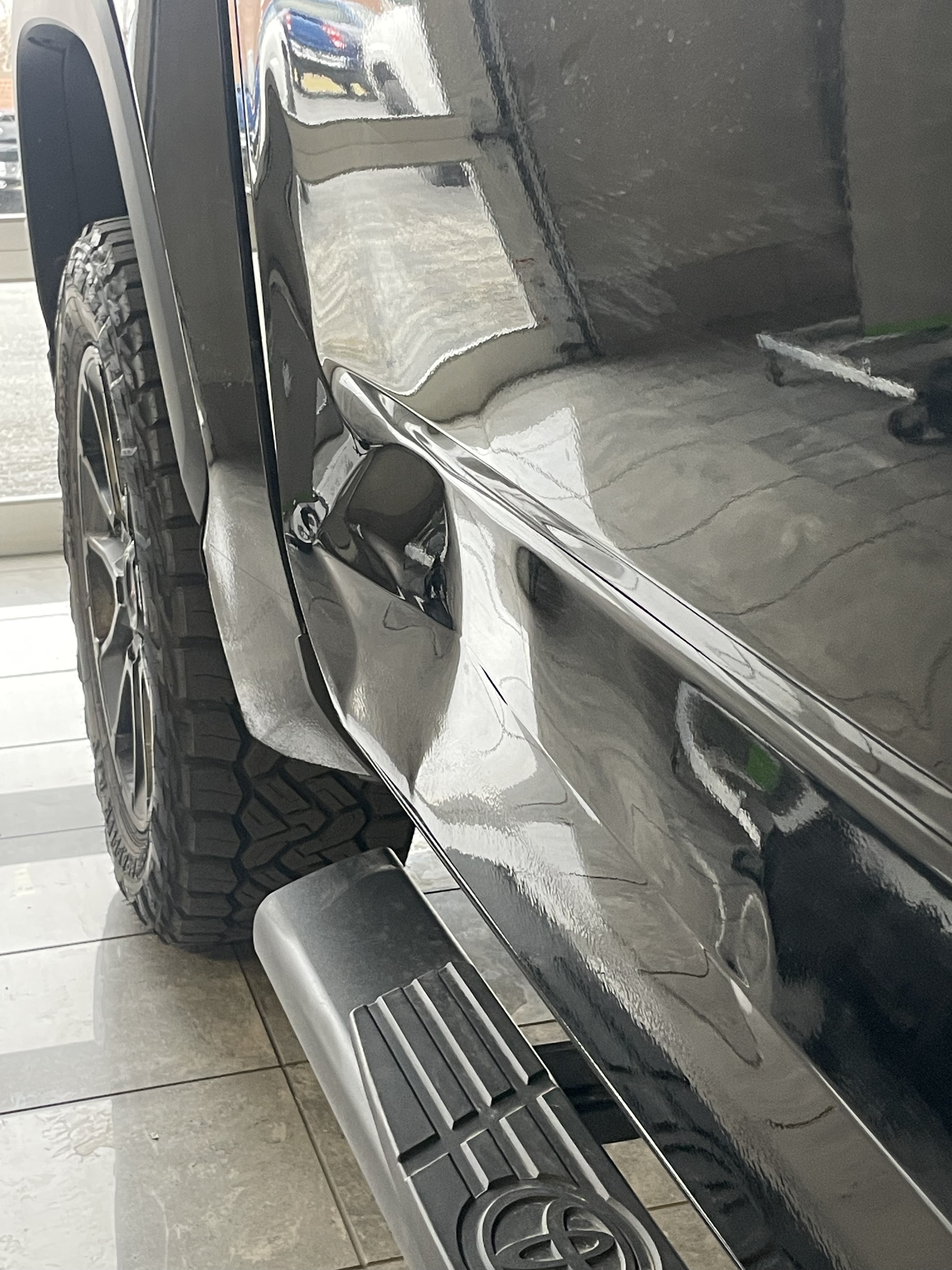 a toyota with a large dent on the rear door