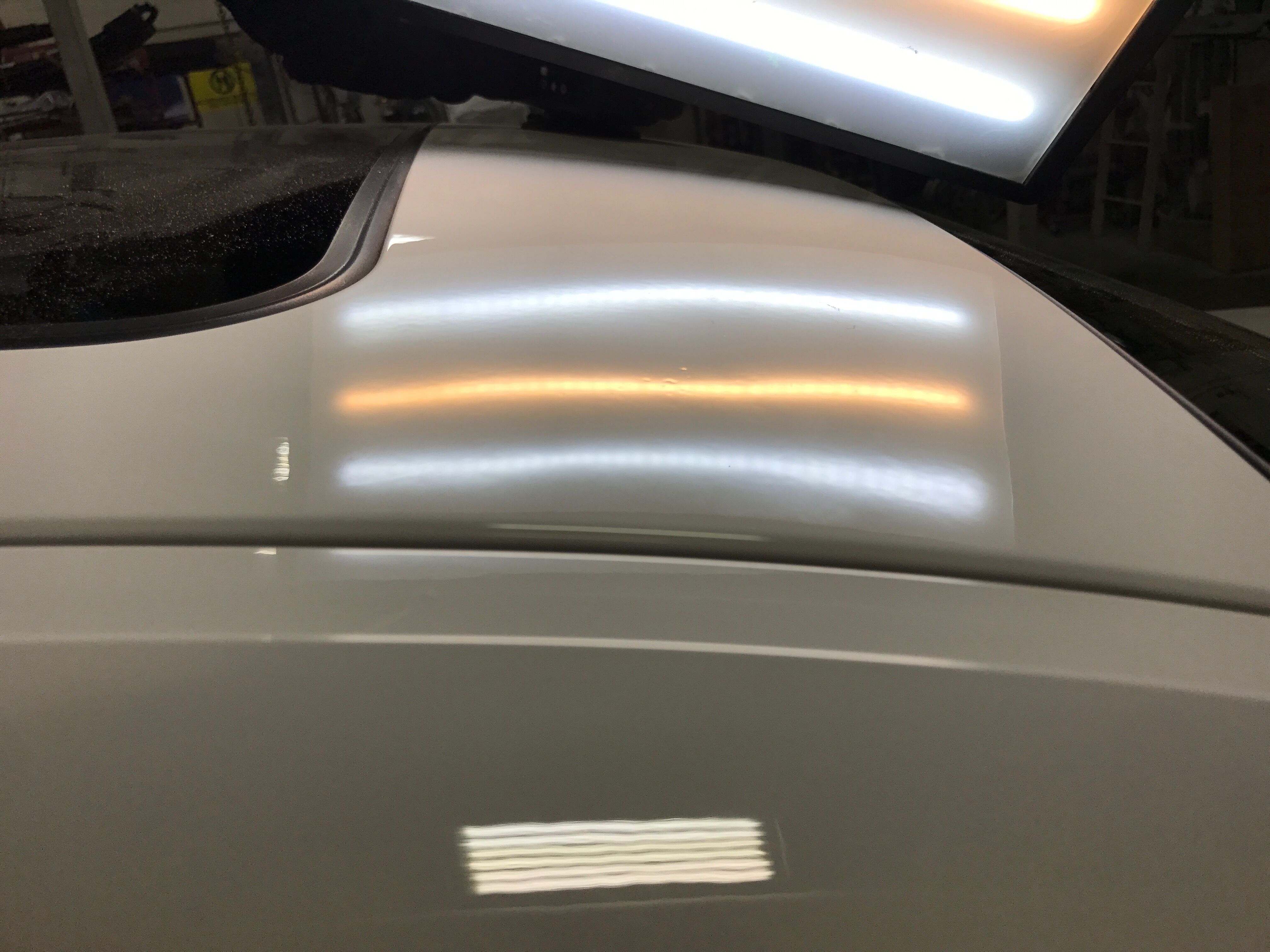 the white car with the huge dent fixed completely